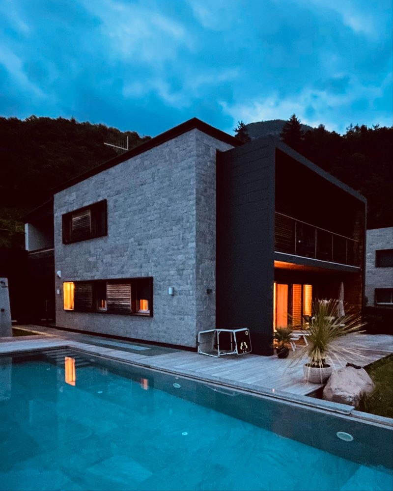 Villa mit Natursteinfassade und Pool am Abend – Beitrag auf Instagram